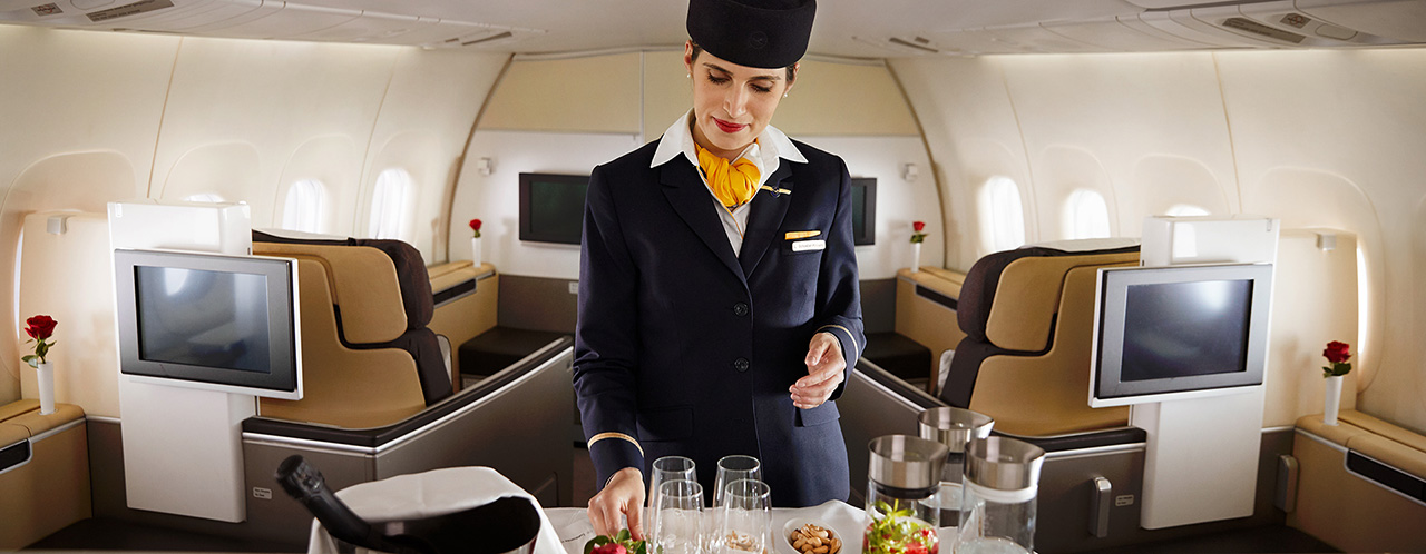 A cabin attendant prepares snacks and drinks for first class on an aircraft