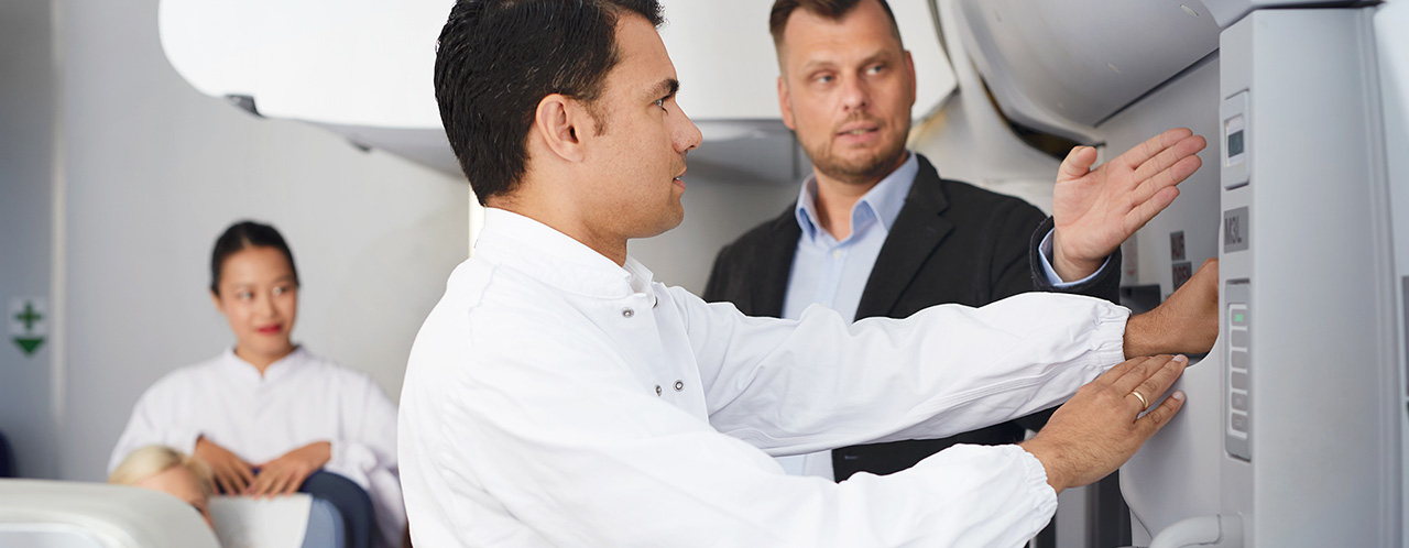 An instructor instructs a trainee in the opening of an aircraft door