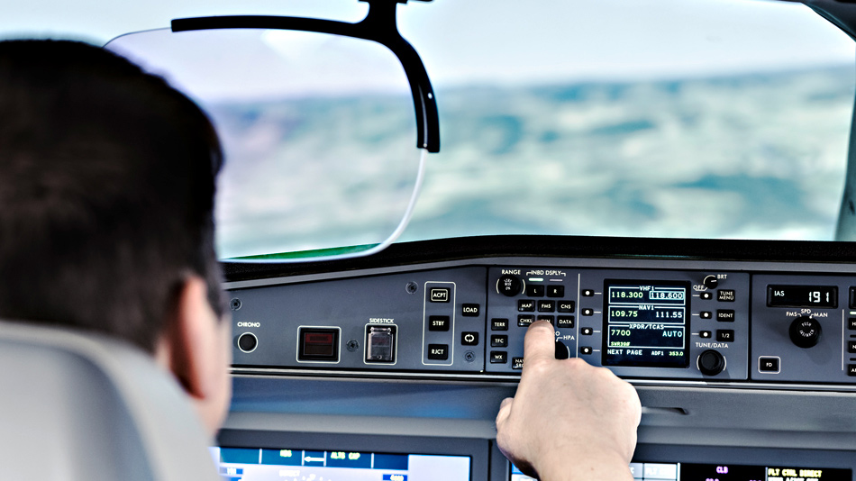 Ein Pilot fliegt mit einem Head up Display und bedient Instrumente im Flugzeug Cockpit
