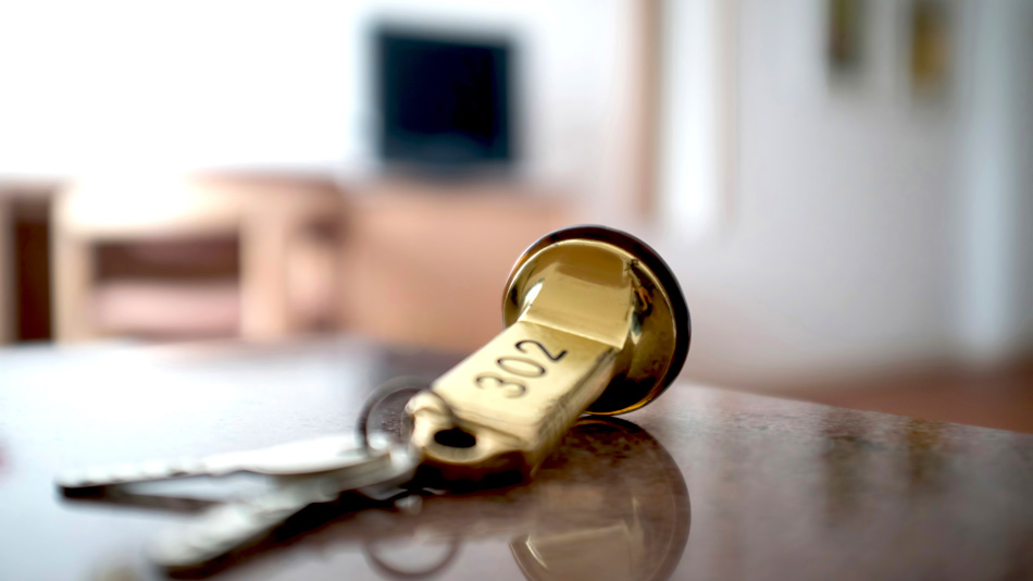 A hotel key with room number 302 is lying on a counter