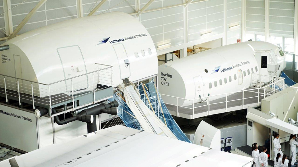 Several Cabin Emergency Evacuation Trainers (CEET) from Lufthansa Aviation Training stand in a training hall