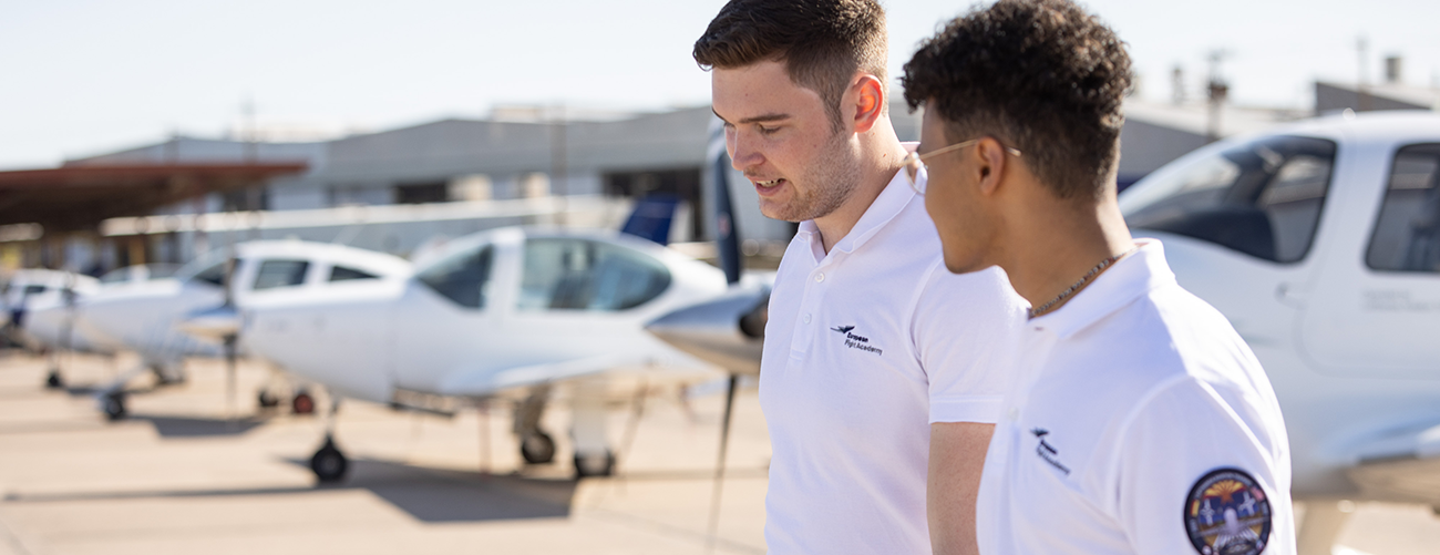 Eine Kapitän:in und eine Flugschüler:in stehen vor einem Airbus A350.