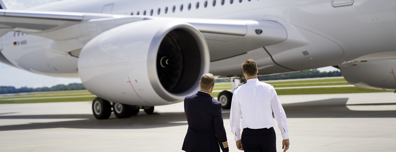 Eine Kapitän:in und eine Flugschüler:in stehen vor einem Airbus A350.