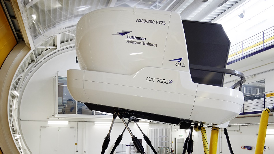 Two people sit in a flight training device and train.