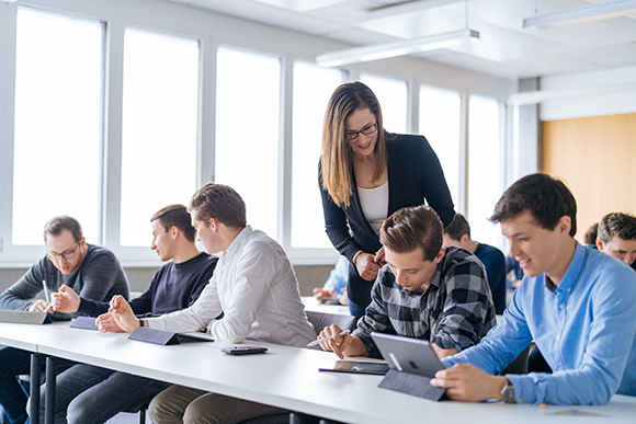 A person is sitting at a desk writing an application for pilot training.
