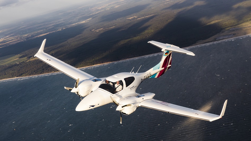 A DA42 of the European Flight Academy is flying over the sea.